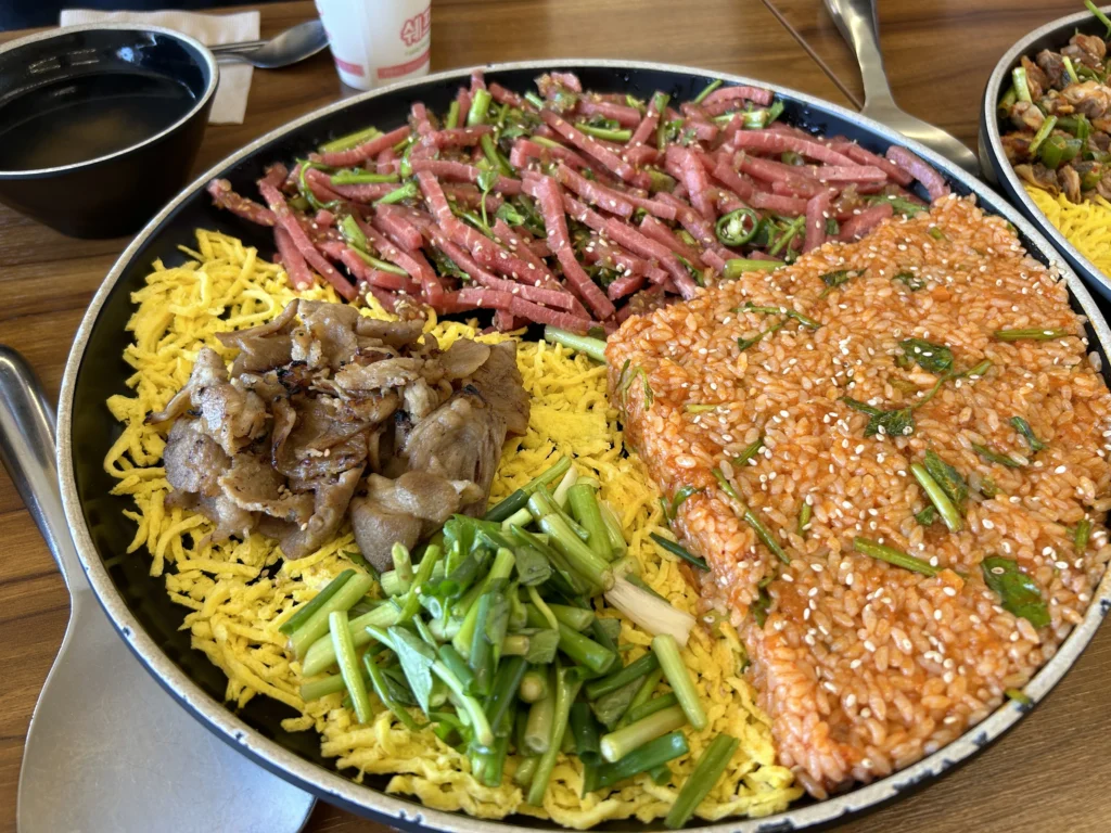 Ssambap — the same wrapping concept applied to a full meal: rice, various meats and vegetables, wrapped in lettuce or perilla at your own pace.