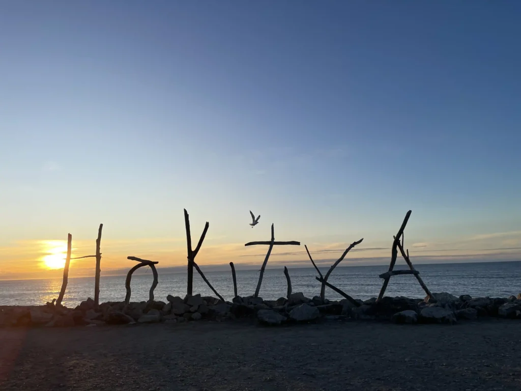 Hokitika Beach Sign — Sunset Timing