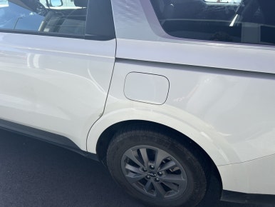 NZ rental car insurance — close-up of door panel scratch on rental Kia Carnival, South Island New Zealand