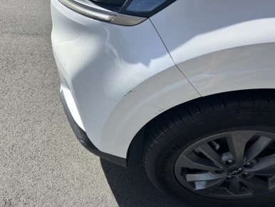NZ rental car insurance — close-up of door panel scratch on rental Kia Carnival, South Island New Zealand