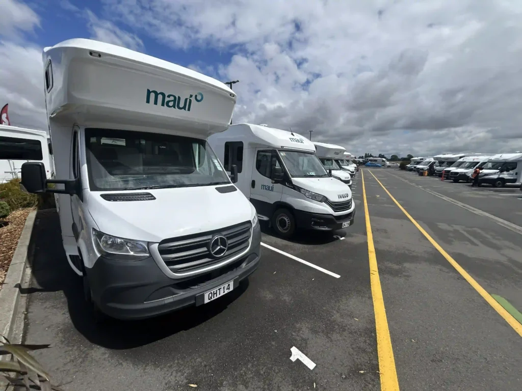 NZ rental car insurance — campervan parked at South Island campsite during family road trip New Zealand