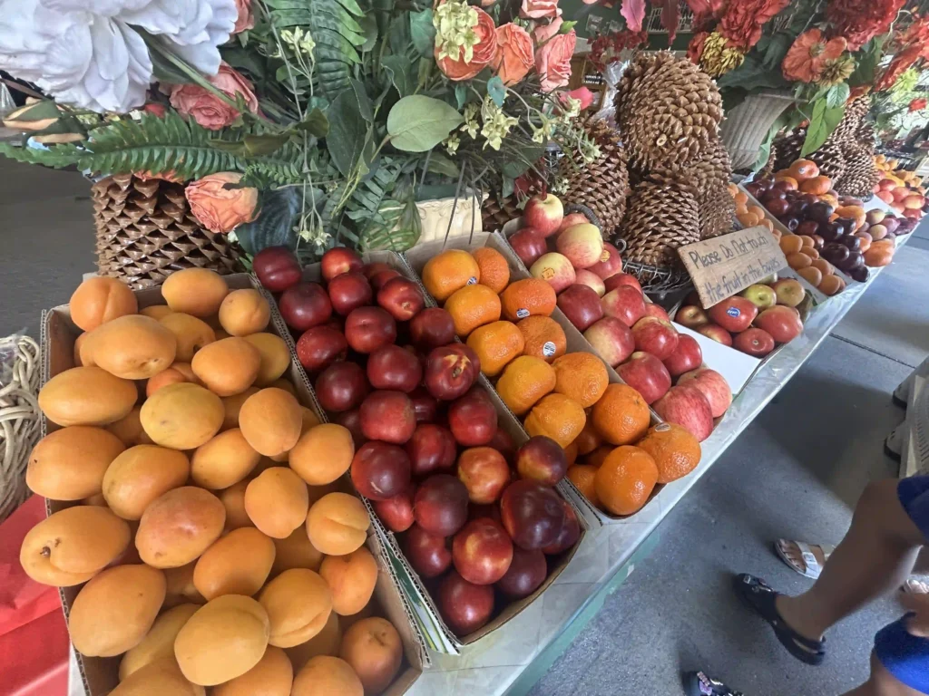 Fresh apricots, nectarines, plums and oranges on display at Cromwell South Island roadside fruit stall — stone fruit direct from Central Otago orchards