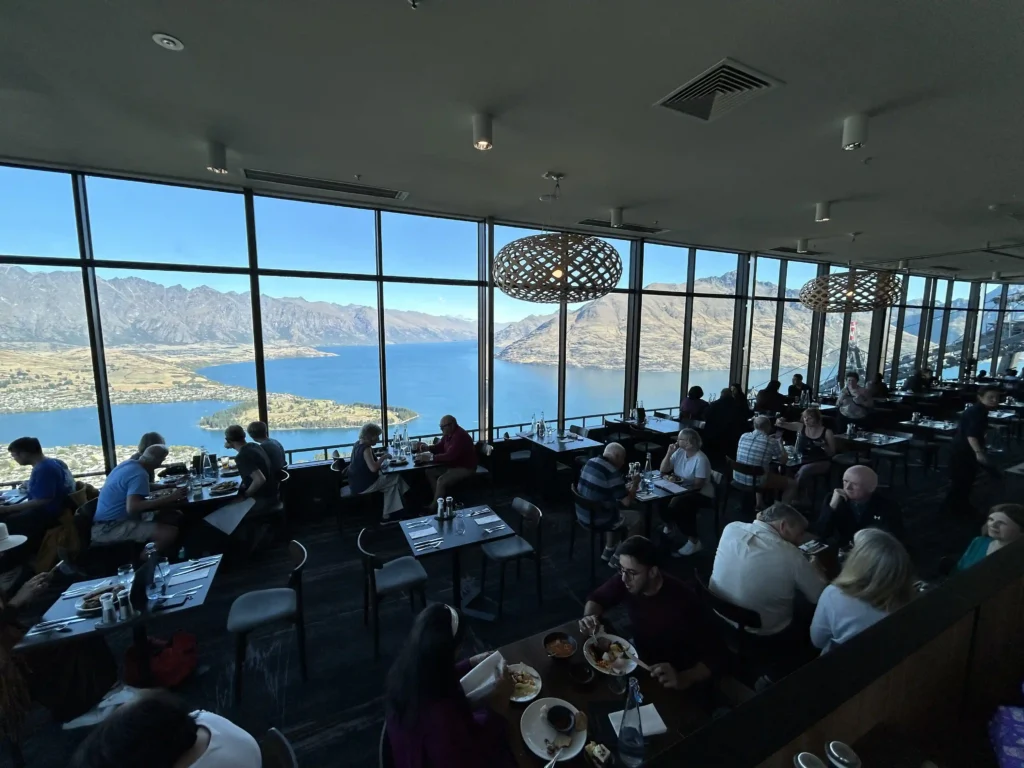 Stratosfare restaurant interior at Queenstown Skyline — full dining room with floor-to-ceiling windows overlooking Lake Wakatipu and The Remarkables